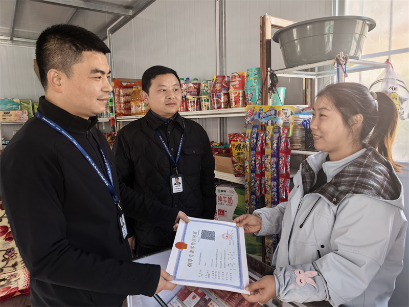 专卖证件管理人员为乡村客户送证上门。郝敬帆摄