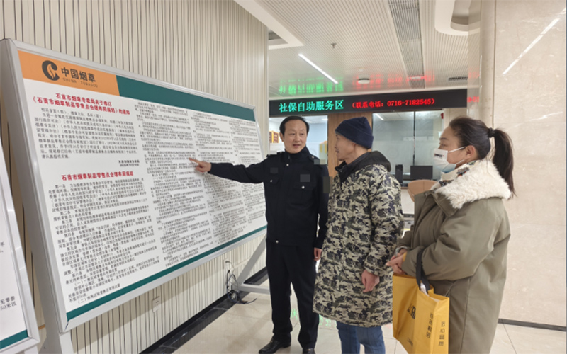 石首烟草工作人员向申请人宣传政策。