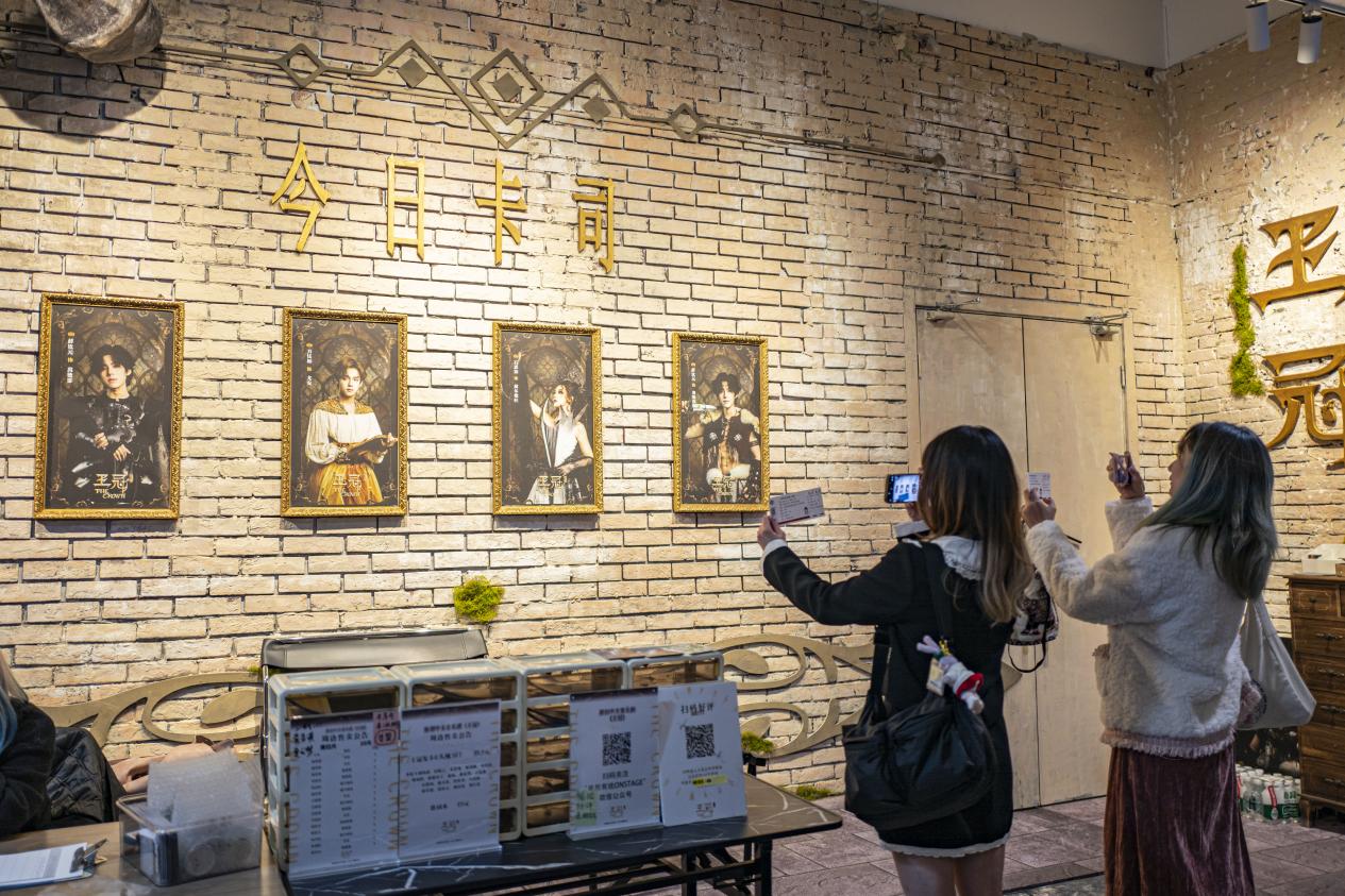 七楼音乐剧《王冠》剧场门口，观众开场前拿着票根打卡拍照。