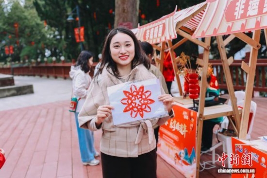 图为游客展示剪纸作品。翁榕飞 摄