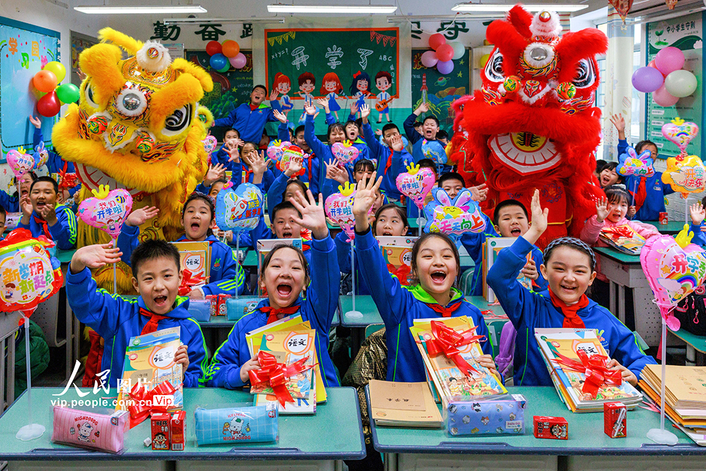 2026年3月1日，新疆乌鲁木齐市第二小学，学生们开心地展示着领到的新书。孙振嵩摄（人民图片网）