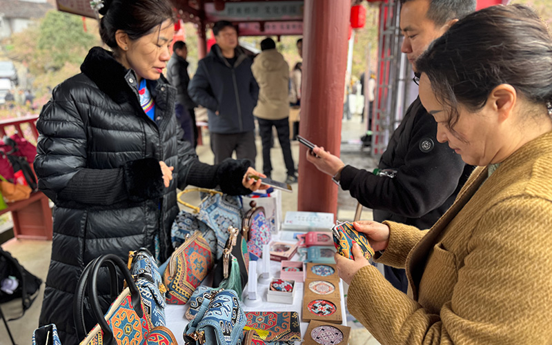 游客在选购土家族传统织锦“西兰卡普”