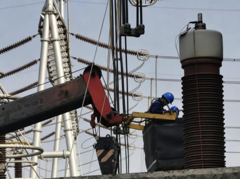 国网湖北直流公司检修人员正在换流变网侧高压套管进行绝缘油离线色谱分析取油工作。方子健摄