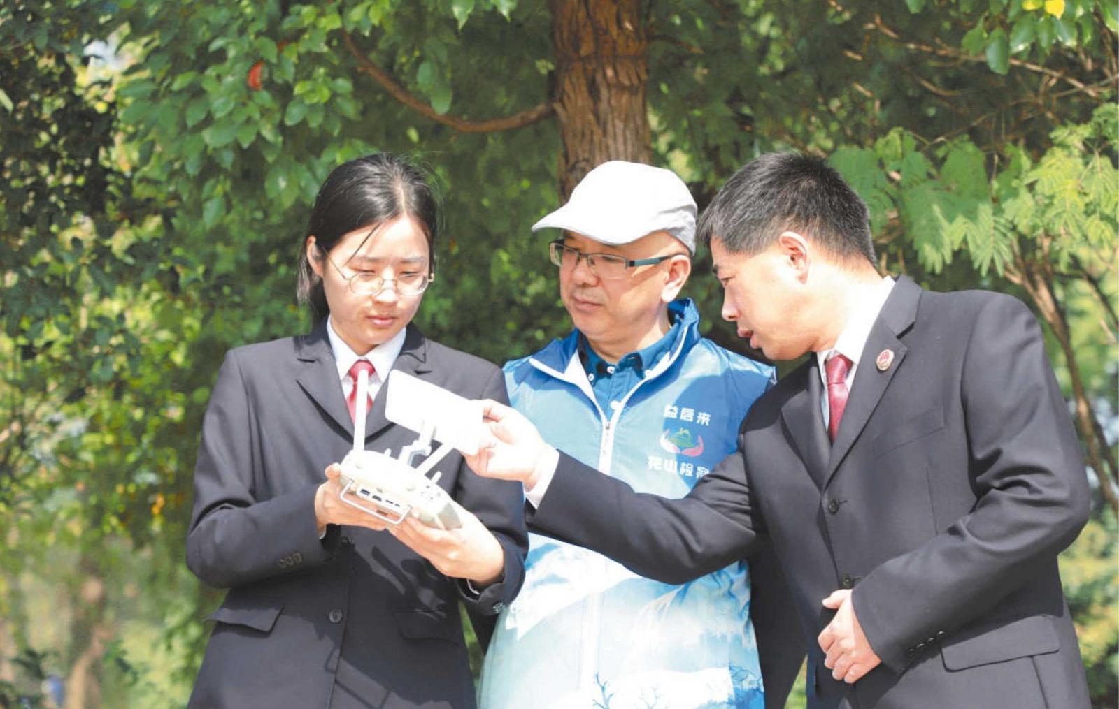 马鞍山市花山区人民检察院干警邀请“益心为公”志愿者、致公党党员王光春参与监督航拍取证。周杨 摄