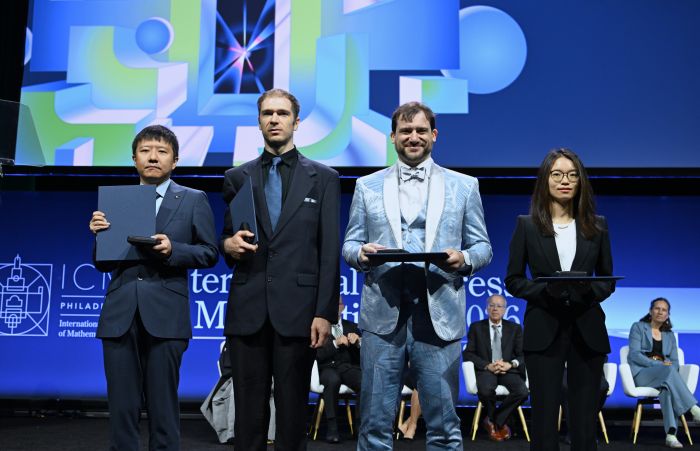 图为2026年7月23日，菲尔兹奖获得者中国数学家邓煜（左一）、王虹（右一）、美国数学家约翰·帕登（左二）和加拿大数学家雅各布·齐默曼在美国费城举行的2026年国际数学家大会开幕式上合影。新华社记者李睿摄