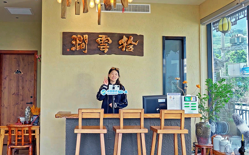 依托中国移动高速网络,田恒兰在自家民宿内开直播。